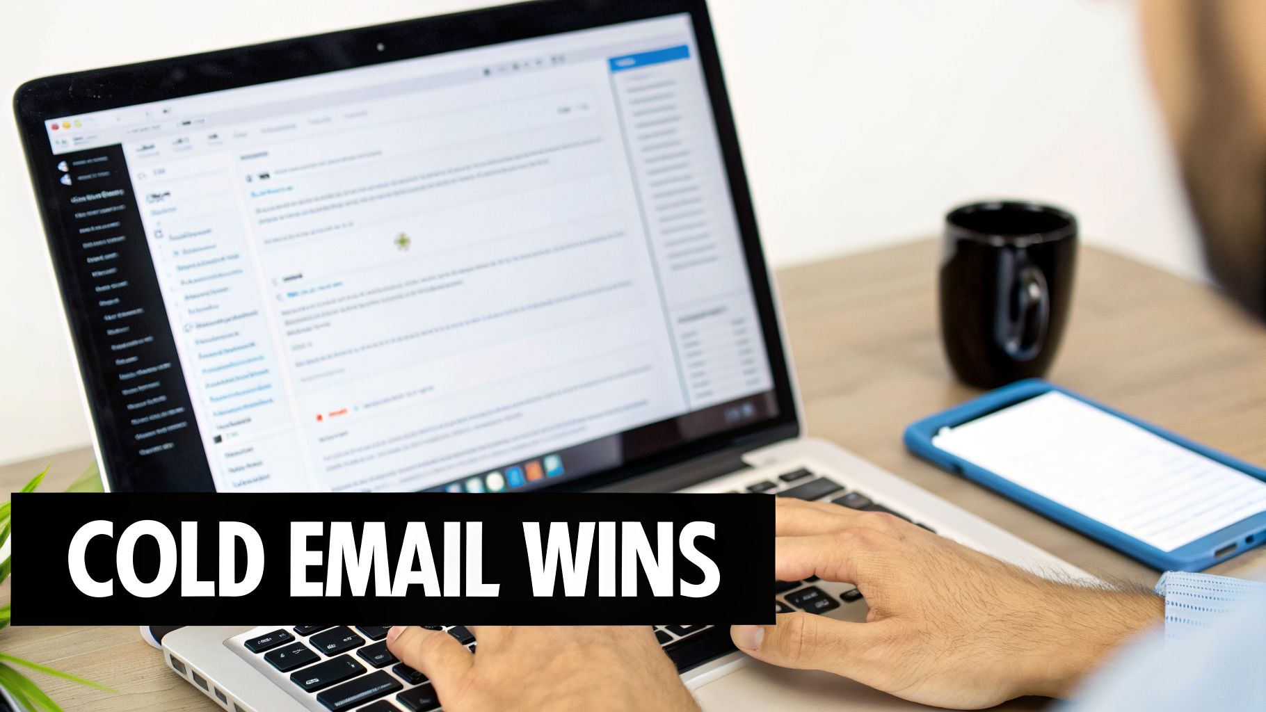 Hands typing on a laptop displaying emails and the text 'COLD EMAIL WINS', beside a phone and coffee.